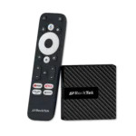Il TV box Android GB1 di RockTek mostrato insieme al suo telecomando dedicato. Il dispositivo compatto ha un design elegante e strutturato. Il telecomando è dotato di un pad di navigazione circolare, di un pulsante per il controllo vocale e di pulsanti dedicati ai servizi di streaming più diffusi, come YouTube, Netflix e Prime Video, oltre a un pulsante "Apps" per accedere rapidamente alle applicazioni installate.
