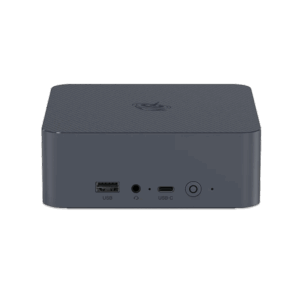 A straight-on front view of a dark grey, square-shaped mini PC with rounded corners, set against a solid dark green background. The top surface has a subtle textured pattern and a circular logo. The front panel features a USB-A port, a headphone jack, a USB-C port, and a power button with a circular LED indicator. All ports and buttons are labeled with white text.