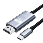 Štúdiová fotografia zobrazuje kovovo strieborný kábel adaptéra Type-C na HD na čiernom pozadí. Na hlavnom tele adaptéra je text v angličtine: "4K UHD Type-C to HD Cable Model TH001 Rev: No.01 Made in China" spolu so symbolmi CE, WEEE a FCC. K tomuto kovovému telu je na jednom konci pripojený konektor HDMI a na opačnom konci čierny izolovaný kábel. Okrem toho je pod hlavným telom zobrazený samostatný konektor typu C so zodpovedajúcim strieborným krytom, tiež s čiastočne viditeľným káblom. Všetky pripojenia sú vybavené čiernou zmršťovacou fóliou alebo plastom v mieste, kde sa káble stretávajú s konektormi.