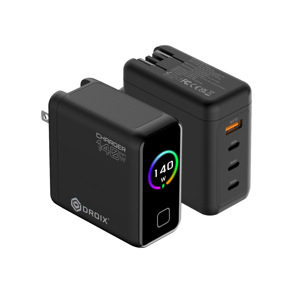A detailed product render of two DROIX 140W GaN Wall Chargers from different perspectives, displayed on a black background. The foreground charger is in a front-three-quarter view. It is a matte black block with its US foldable plug partially extended on the left side. On its side, prominent white text reads "CHARGER 140W" with a large "O" and a small "140" above the "O," and the DROIX logo below it. The front glossy black face features a central circular display with a dynamic rainbow-colored ring around the white text "140 W" and a small green charging icon. Below the display is a button or LED indicator. The background charger is in a rear-three-quarter view, showing the ports and text details. It lists extensive multi-line technical specifications and safety certifications in small white text (such as model numbers, voltage/current ratings, and CE, FCC, UKCA marks). This unit displays its four output ports: from top to bottom, one orange-accented USB-A port labeled with small text "22.5W Max," followed by three USB-C ports labeled in order "40W", "100W", and "140W". Both units show top ventilation grills. This composition provides a comprehensive view of the charger's branding, display, and port capabilities.